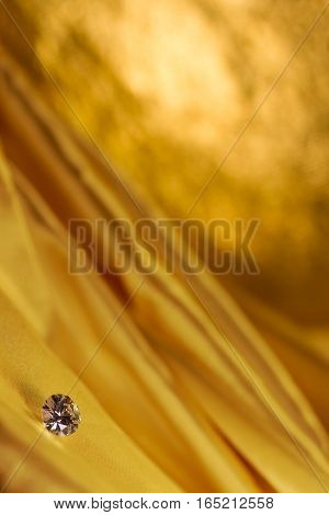 Beautiful big diamond jewelry on golden satin cloth background. Fine natural precious stone