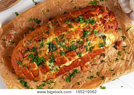 Homemade Cheese Garlic Pull Apart Bread with herbs on crumpled paper.