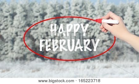 Woman Hand Writing Happy February With Marker Over Winter Forest.