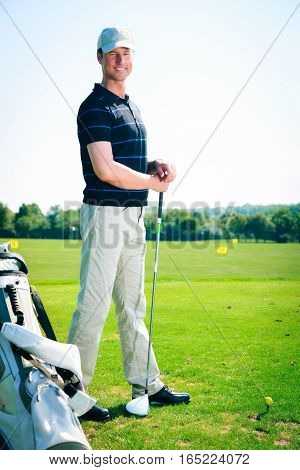 a golf player is practicing on the driving range