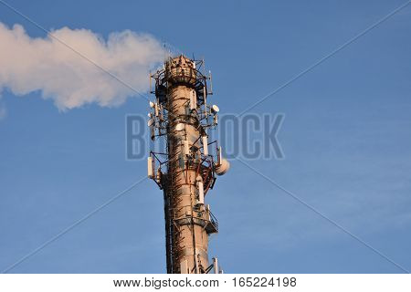 heating the smoke pipe of a heating plant in the background of blue sky