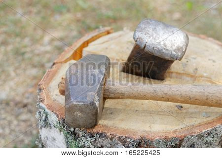 Sledgehammer and a wedge splitting a birch log