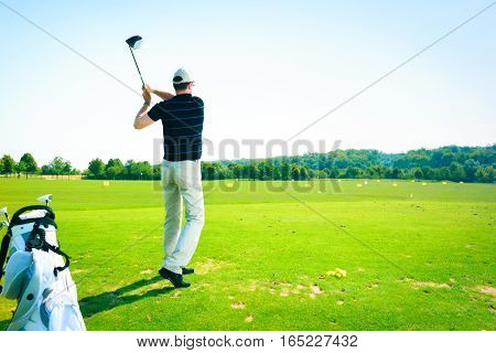 a golf player is practicing on the driving range