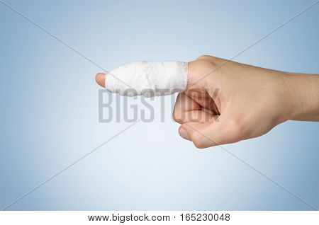 Injured painful finger with white gauze bandage