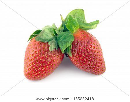 Two ripe appetizing red strawberries with green leaves isolated closeup