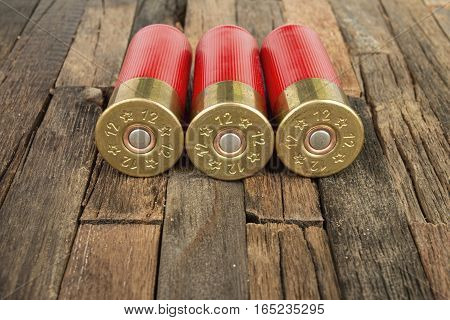 12 gauge red hunting cartridges for shotgun on wooden background. Macro shot.