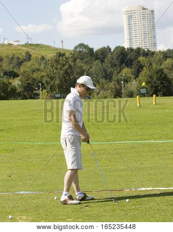 MOSCOW - AUGUST 17 2013: man plays golf on golf-fields in sport complex Krylatskoye in region Krylatskiye hills.