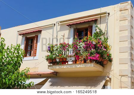 Rethymnon Island Crete Greece - June 23 2016: A balcony with lot of pots with flowers in the second part of old house located in Old Town of Rethymnon