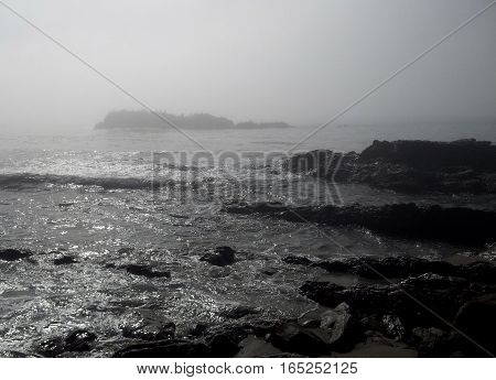 A rocky section of coast near Laguna Beach, California on a foggy morning.