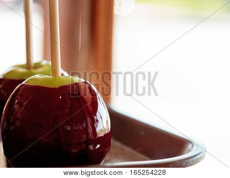 Candy apples with caramel and nuts on a stick in a candy store window