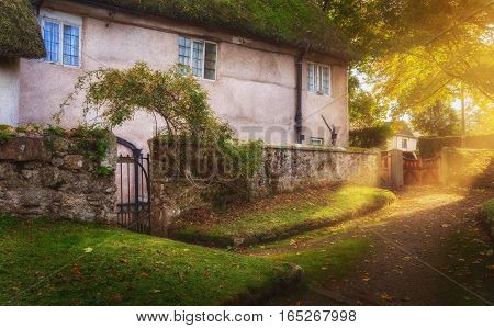 Courtyard at the old two-storey house. Evening. Autumn. A ray of sunshine breaking through leaves. Chagford. Dartmoor. Devon. UK