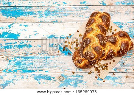 Two fresh bun with raisins and poppy seeds on wooden background.