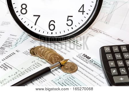 Calculator clock coins and pen on tax form 1040. Bosiness concept.