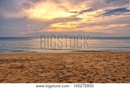 The sands of Mai khao beach in Talang city on Phuket Island thailand overlooking the andaman sea at sunset.