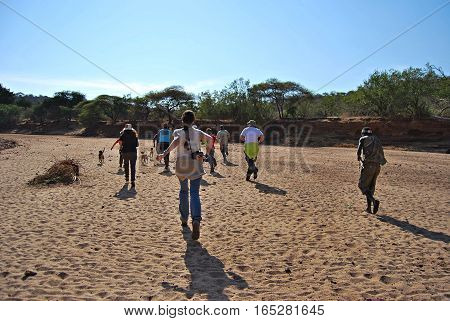 A group of people running and enjoying in a safari. Tanzania