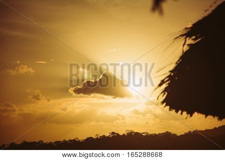 Sun passing behind a cloud at sunset