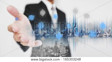 Double exposure businessman stretch out hand with modern buildings and pixel cubes, business network technology