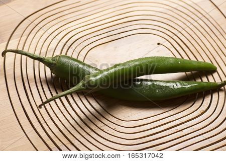 two of green chili with wooden background