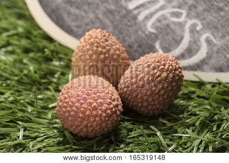 fresh lychees fruit on grass background, closeup
