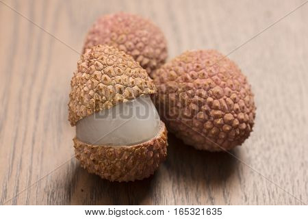 fresh lychees fruit on wooden background, closeup