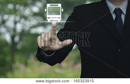 Businessman pressing bus flat icon over blur flower and tree Business transportation service concept