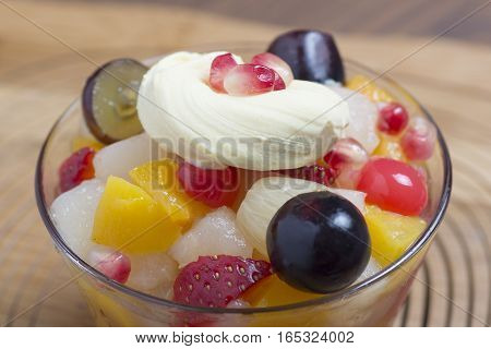 fruit salad in glass on wooden background