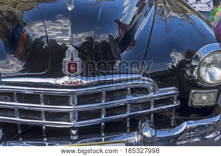 MOSCOW RUSSIA - OCTOBER 1 2016: Fragment of the front of the old Soviet car ZIM (GAZ-12) - the radiator grille headlight and logo on the hood.