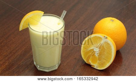 Healthy Orange Fruit Smoothie In A Stemless Glass On Wooden Background With Fresh Oranges Slices