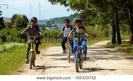 Vietnamese Children Ride Bicycle On Country Road