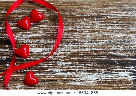 Red hearts border on wooden background with copy space. Minimalist concept for love or Saint Valentine's