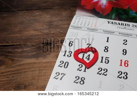 A calendar with hearts on the wooden table
