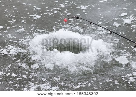 A hole in ice and fishing rod