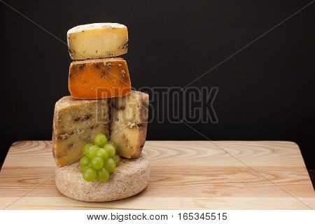 Different kinds of cheese and grape on a wooden table