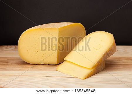 Sliced piece of cheese on a wooden table