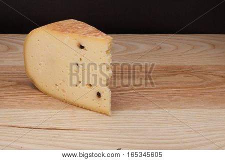 Sliced piece of cheese on a wooden table