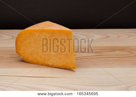 Sliced piece of cheese on a wooden table