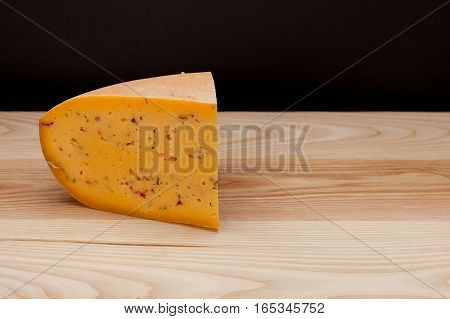 Sliced piece of cheese on a wooden table