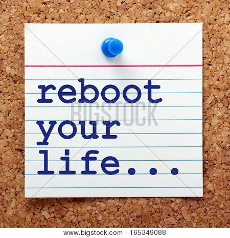 The words Reboot Your Life in blue text on a card pinned to a cork notice board as a reminder to review your goals and aspirations