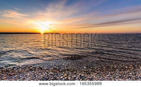 Stones On A Beach With Sunset On The Ocean Sea.