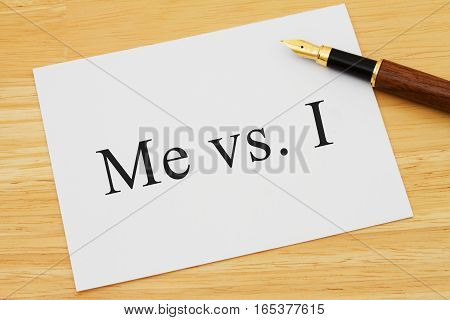 Learning to use proper grammar A white card on a desk with a pen with words Me vs I