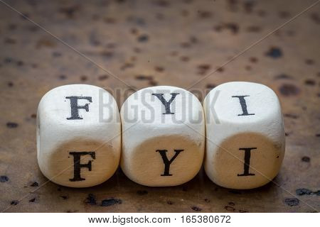 Fyi (for Your Information) Text On Wooden Cubes On A Brown Cork Background
