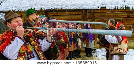 Uzhgorod Ukraine - January 15 2017: Member of folklore band plays on trembita during the seventh ethnic festival Christmas Carols in the old village. During the festival visitors can familiarize with a variety of Christmas customs caroling and celebration