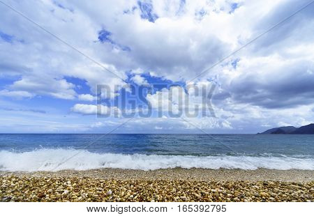 Beautiful sea paradise beach on a background of blue sky with clouds.