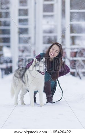 Portrait of Pretty Smiling Woman Hugging Her Husky Dog Outside. Vertical Image Composition