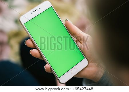 Beautiful girl holding a smartphone in the hands of a green screen green screen, hand of man holding mobile smart phone with chroma key green screen on white background, new technology concept