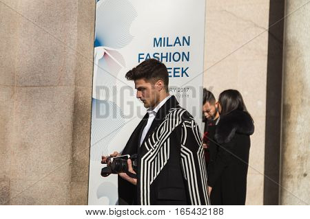 MILAN ITALY - JANUARY 14: Fashionable man poses outside Antonio Marras fashion show building during Milan Men's Fashion Week on JANUARY 14 2017 in Milan.
