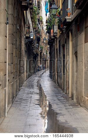Puddle after rain in a narrow alley of the Barri Quarter of Barcelona in Catalonia, Spain