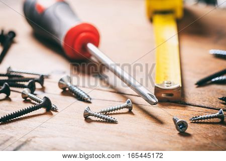 Screwdriver And Nails On Wooden Background