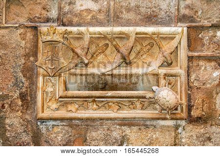 Stone letterbox with carved birds, turtle and leaves of the Casa Ardiaca in Barcelona, Catalonia, Spain