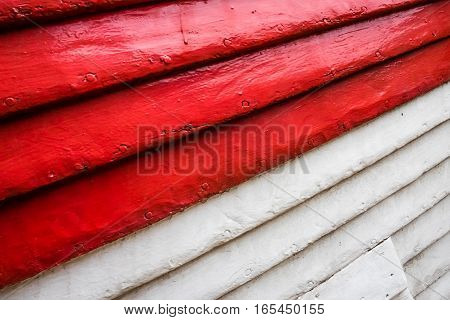 Red and white rows of painted wooden side of a fishermen boat